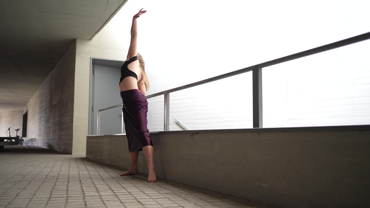 Uma dança elegante acontecendo em espaço urbano, com movimento expressivo e gesto gracioso.