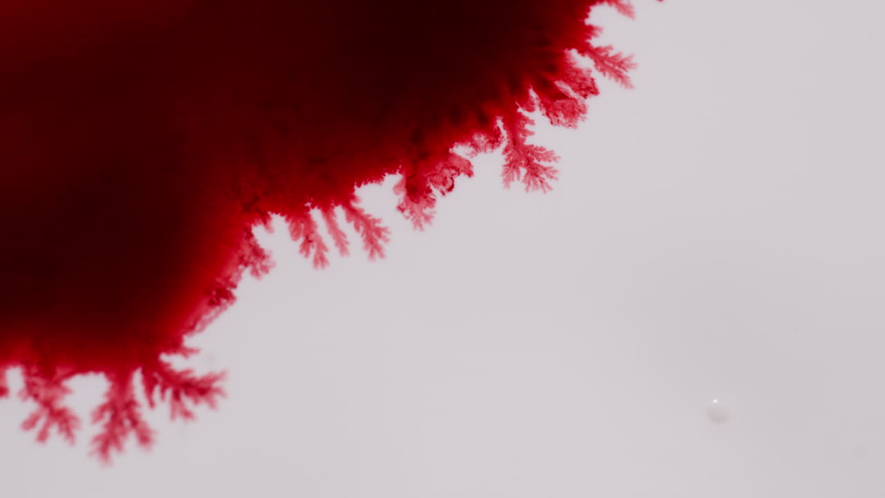 Red Ink Diffusing In Water Creating Abstract Background