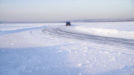 car driving on a snow-covered ice track in winter