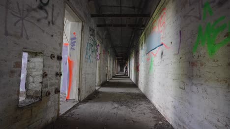 corridor stretches endlessly into shadows as two men walk through, slow-mo