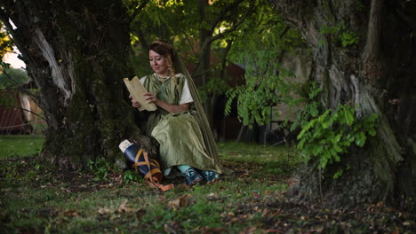 woman reading a scroll under a tree