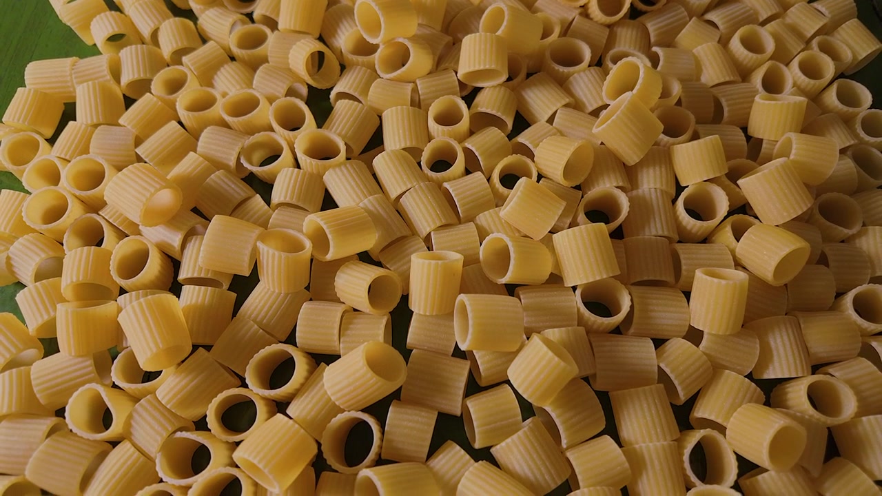 Ripresa macro con slider a 50p dall'alto sopra pasta mezze maniche cruda.