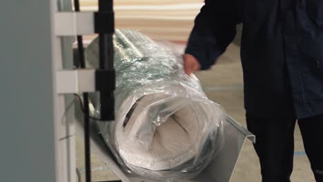 close-up of compressed mattress wrapped in stretch film on a factory automated packaging line for compressed mattresses