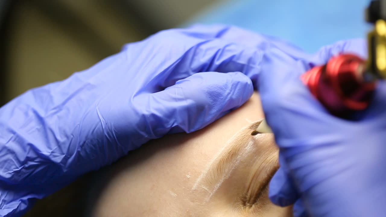 Tattooist using tattoo pen machine for eyebrows permanent make up