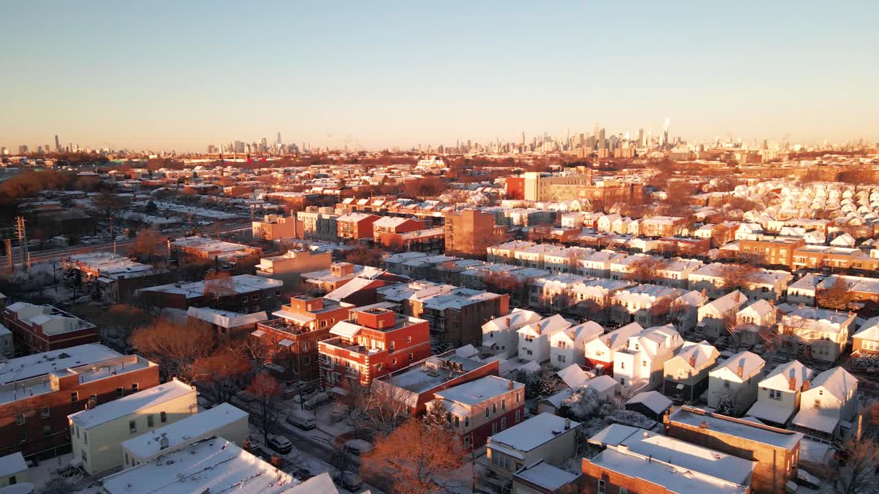 Pan Shot of Snow-Covered Urban Houses at Sunrise with Golden Light Casting a Warm Winter Glow