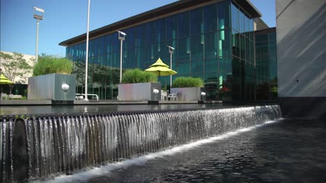 arquitectura moderna con cascada sobre una pared de piedra en una piscina de agua en la biblioteca pública de whitby en canadá