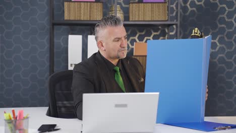 hombre de negocios trabajando mirando archivos de papeleo.