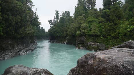 slowmo - glacier river flows through native lush new zealand forest, hokitika gorge, south island