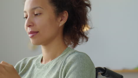 cheerful woman in wheelchair texting on phone