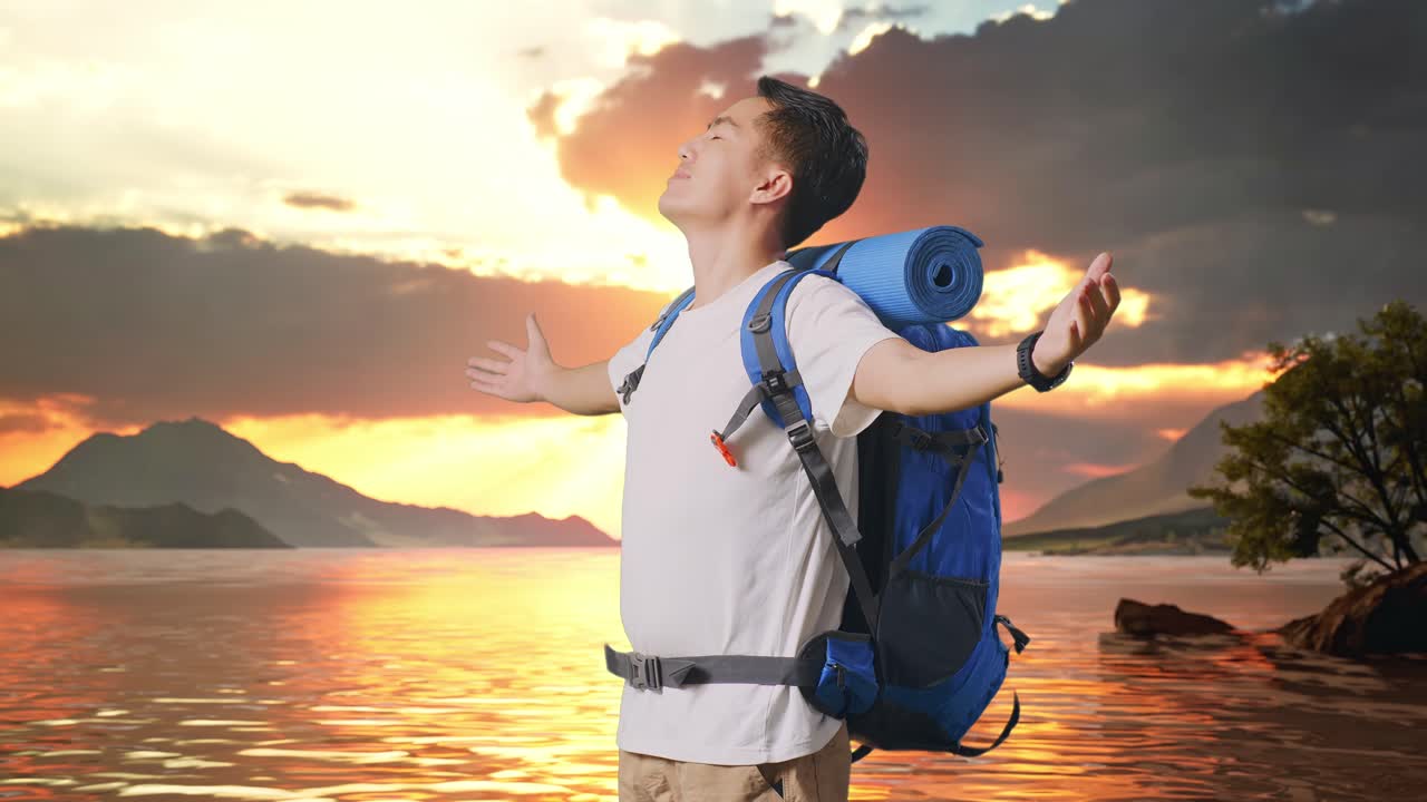 vista lateral de un excursionista masculino asiático con una mochila de montañismo sonriendo y abriendo los brazos disfrutando de la vista alrededor de un lago