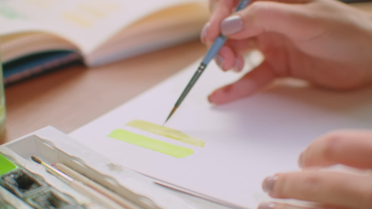 Young woman with brush and paint making color matching create color palette for color matching for design