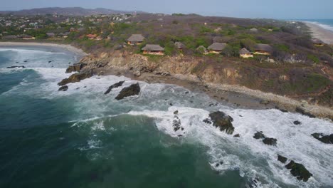 rising aerial view of punta zicatela with waves crashing along the tropical beaches