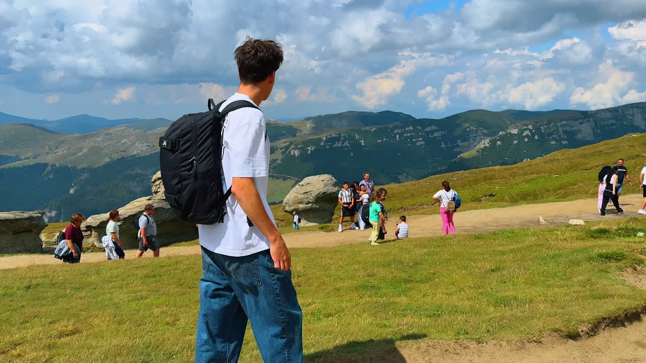 Tourists exploring Bucegi Mountains near Sphinx. Group of tourists walking and exploring the Bucegi Mountains landscape near famous Sphinx rocks