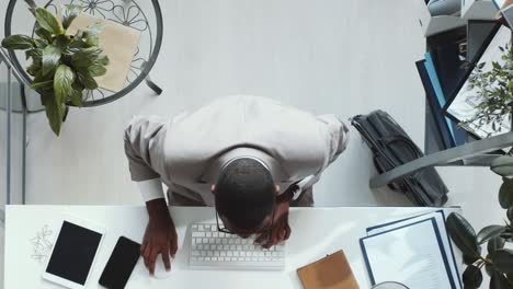 excited afro-american businessman working at desk and celebrating success