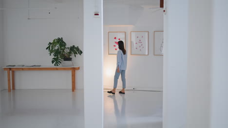 gallery visitor looking paintings on weekend. woman walking contemporary museum