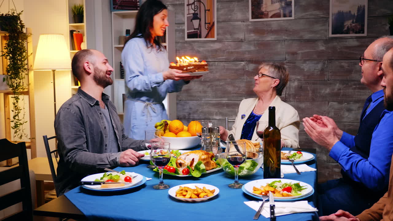 siguiente foto de una mujer trayendo un pastel de cumpleaños para su madre