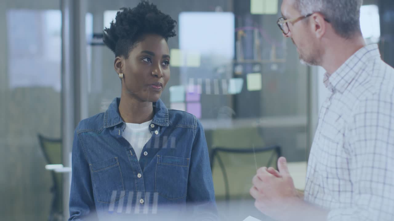 Man pointing, sparking woman looking at sticky notes in office by glass, guiding with graphics