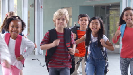 group of elementary school kids running in a school corridor