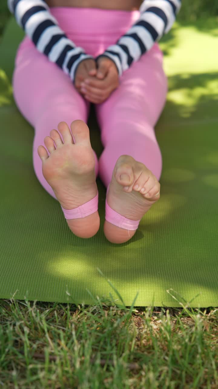 요가 매트 에 앉아 스트레칭 하는 여자