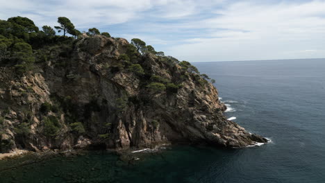 Disparo-De-Drones-Rodeando-Una-Roca-En-Giverola,-Costa-Brava