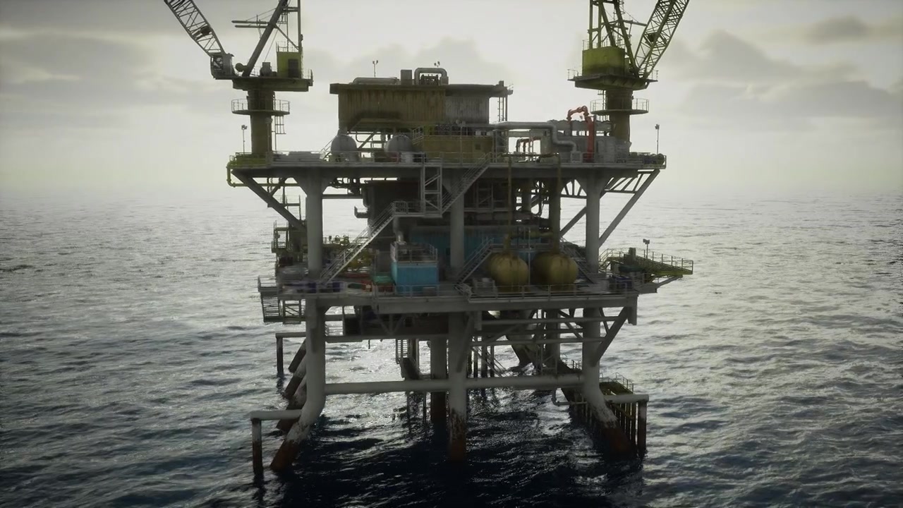 Fjern stål offshore-installation med kraner mod en skyet horisont.