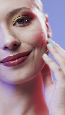 vertical video of caucasian woman with brown hair and make up touching face, copy space, slow motion