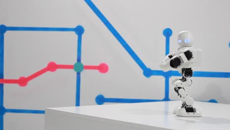 Smart robot toy dancing. White toy robot dance on podium