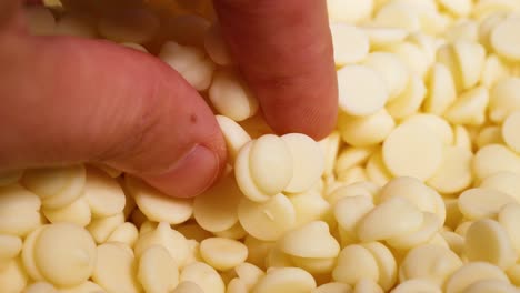 fingers interacting with white chocolate chips