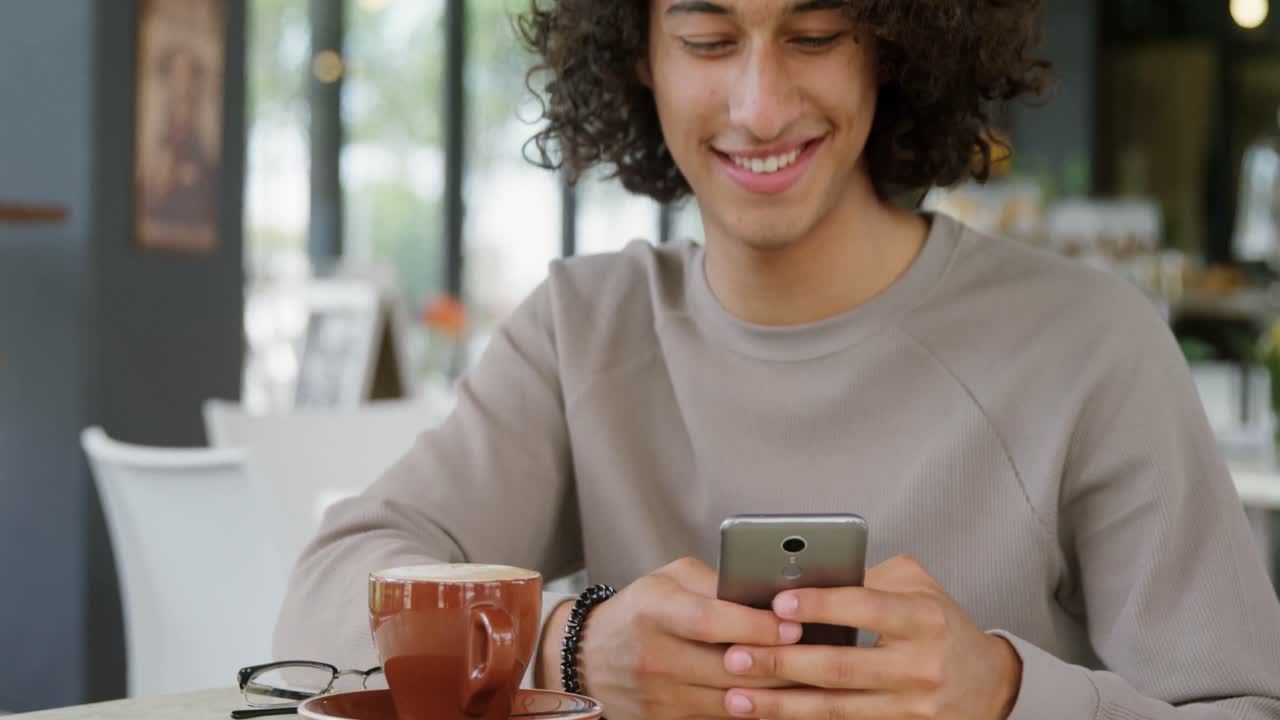 uomo che usa il cellulare in una caffetteria 4k