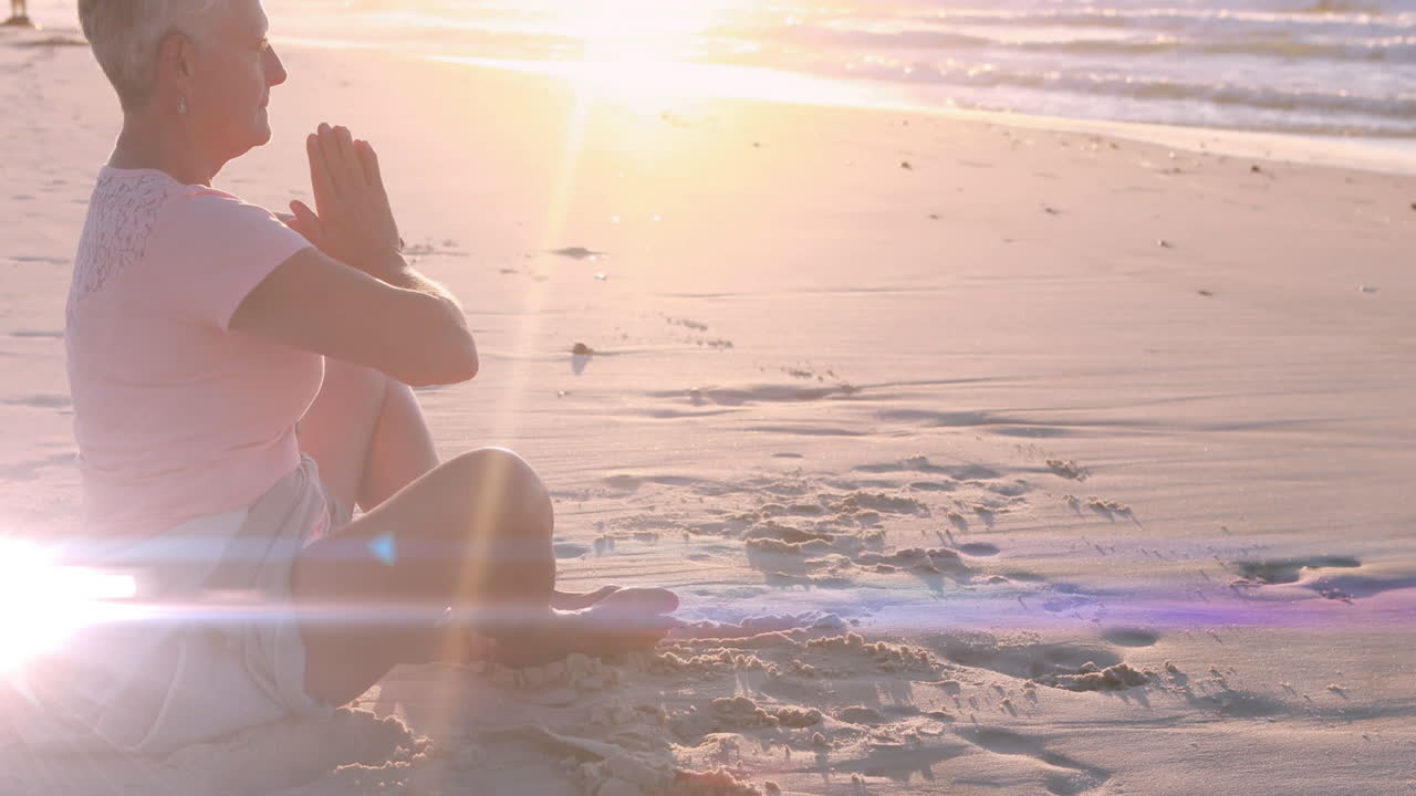 해변에서 요가를 연습하고 명상하는 백인 여성 위에 빛의 반점의 애니메이션