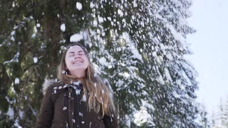 niña lanzando nieve fresca en el aire a cámara lenta