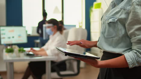 close up of employee using tablet standing in new normal office room