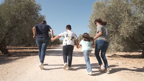 rear view of a family running together on a rural path