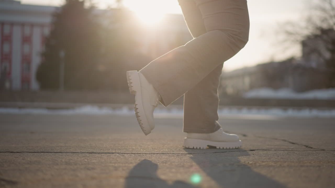 Girl tap dancing on wet tiled pavement, melting snow lining edges, water droplets scattering with precise foot movement, capturing urban winter energy and easy street rhythm under morning sunlight