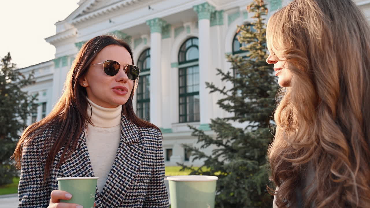 Two women talking and drinking coffee at a terrace