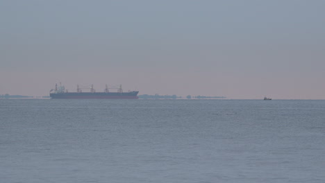 Vögel-Fliegen-Im-Meer,-Im-Hintergrund-Schwimmt-Ein-Lastkahn