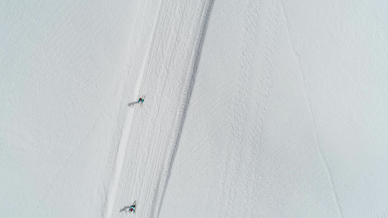 vista aérea de arriba hacia abajo que muestra a un grupo de amigos esquiando en las montañas del jura, francia - valle de combe a la chèvre