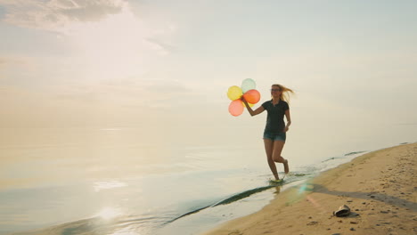 Sorglose-Junge-Frau,-Die-Am-Strand-Läuft-und-Ballons-In-Der-Hand-Hält-Konzept---Die-Leichtigkeit-Der-Freiheit-Jo