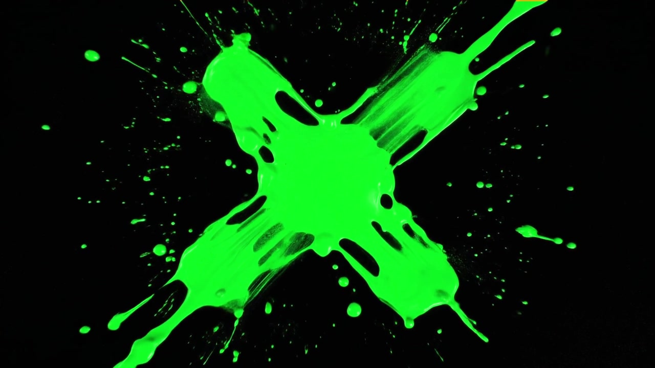 Vernice verde che schizza formando una X su sfondo nero