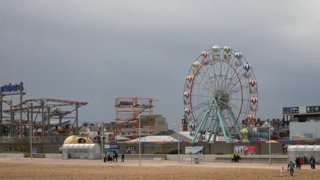amusement park with ferris wheel and roller coaster by the beach