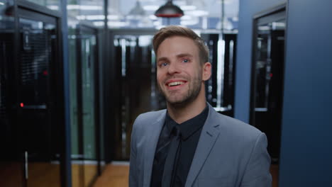 handsome guy looking at camera in office. friendly man smiling in corridor