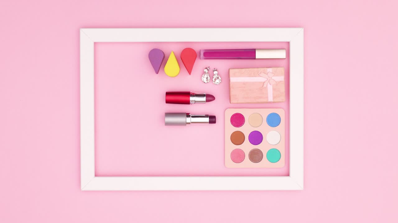 핑크 테마의 프레임에서 화장품과 보석이 나타나고 사라집니다. 움직임을 멈추십시오.