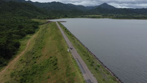 Vehicle-driving-alongside-Yang-Chum-Reservoir,-freshwater-fish-breeding-area-in-Thailand