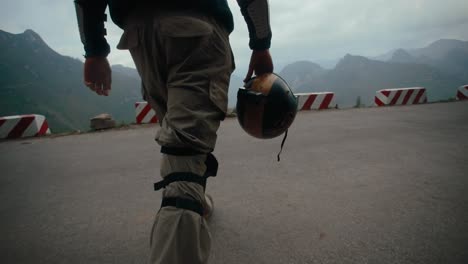 Biker-walking-down-road-in-slow-mo,-Ha-Giang-Loop