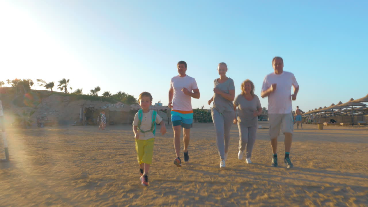 familia deportiva corriendo en la playa