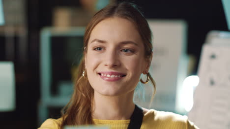 smiling business woman taking off sticker from glass board in hipster office