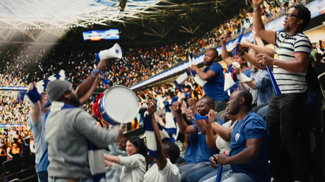 Voetbalsupporters leiden blauwe stadiongezangen met trommel en megafoon