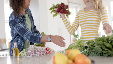 Happy-diverse-couple-unpacking-shopping-bags-in-ktichen,-slow-motion