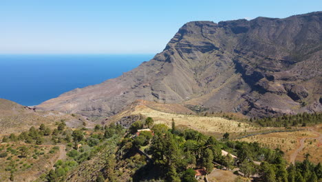 Tamadaba-Natural-Park,-Tirma:-aerial-view-in-orbit-in-a-fantastic-landscape-with-high-mountains-like-Roque-Faneque