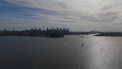 aerial: sydney skyline and cityscape during the day in the capital city of the state of new south wales, australia, establishing drone shot